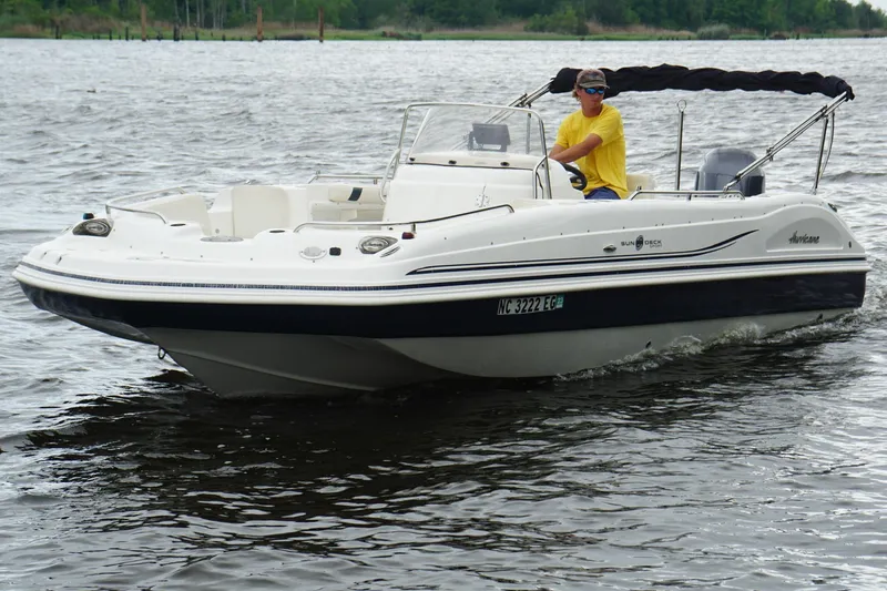 Slide: The Image of 2015 Hurricane SunDeck Sport 231 OB boat cruising on a calm lake. - 20