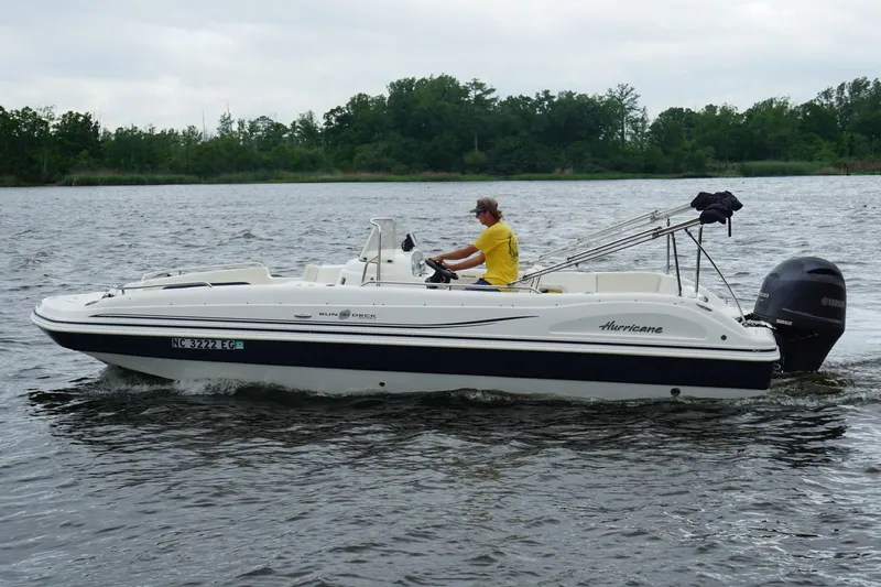 Slide: The Image of 2015 Hurricane SunDeck Sport 231 OB boat cruising on a lake with a driver. - 22