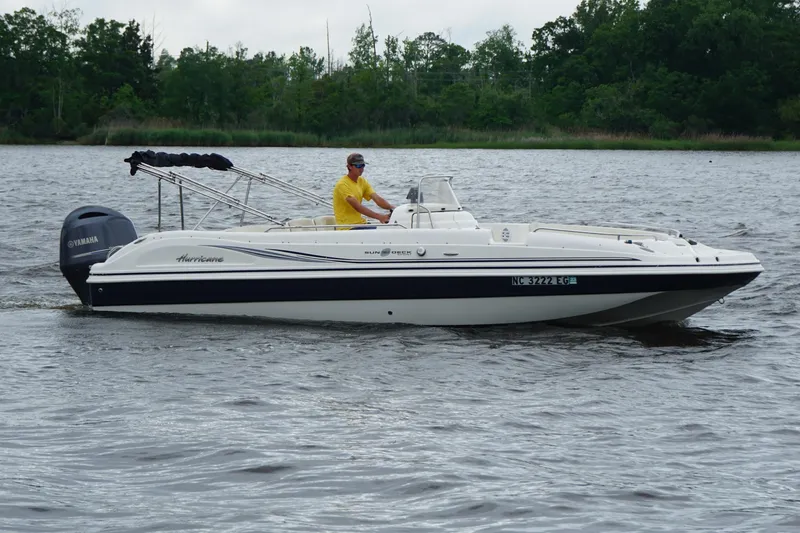 Slide: The Image of 2015 Hurricane SunDeck Sport 231 OB boat cruising on a lake with a Yamaha outboard motor. - 4
