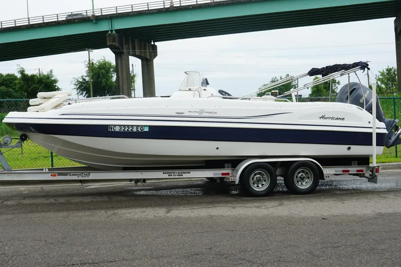 Slide: The Image of 2015 Hurricane SunDeck Sport 231 OB boat on trailer under bridge. - 5