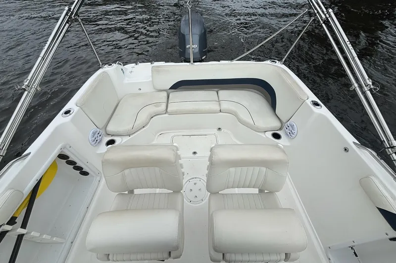 Slide: The Image of 2015 Hurricane SunDeck Sport 231 OB boat interior with white seating and water backdrop. - 7