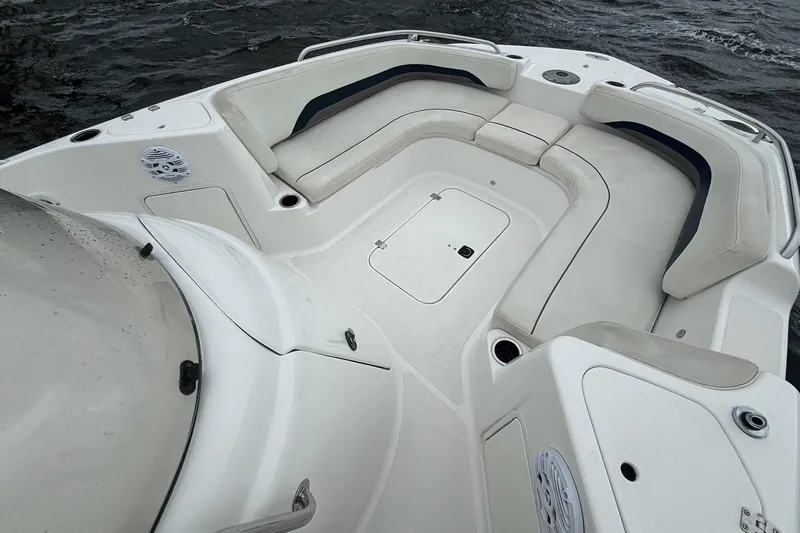 Slide: The Image of 2015 Hurricane SunDeck Sport 231 OB boat interior with white seating and storage compartments. - 9