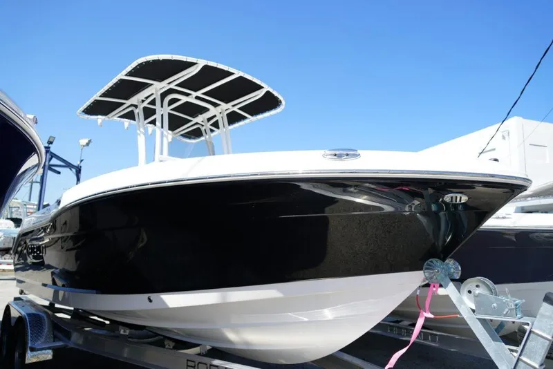 The Image of 2025 Robalo R200 Center Console boat on trailer, featuring sleek black and white design. - 1