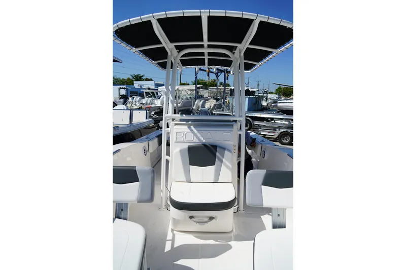 Slide: The Image of 2025 Robalo R200 Center Console boat with T-top and seating, docked outdoors. - 12
