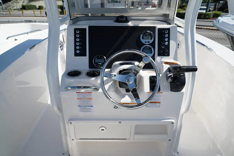 Slide: The Image of 2025 Robalo R200 Center Console boat dashboard with steering wheel and controls. - 19