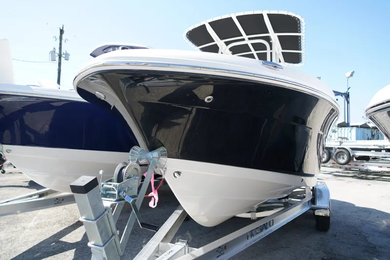 Slide: The Image of 2025 Robalo R200 Center Console boat on trailer, sleek black and white design. - 2