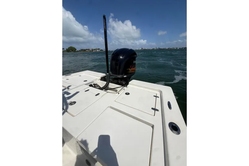 Slide: The Image of 2012 Pathfinder 2200 TRS boat on water, showcasing rear deck and motor. - 11