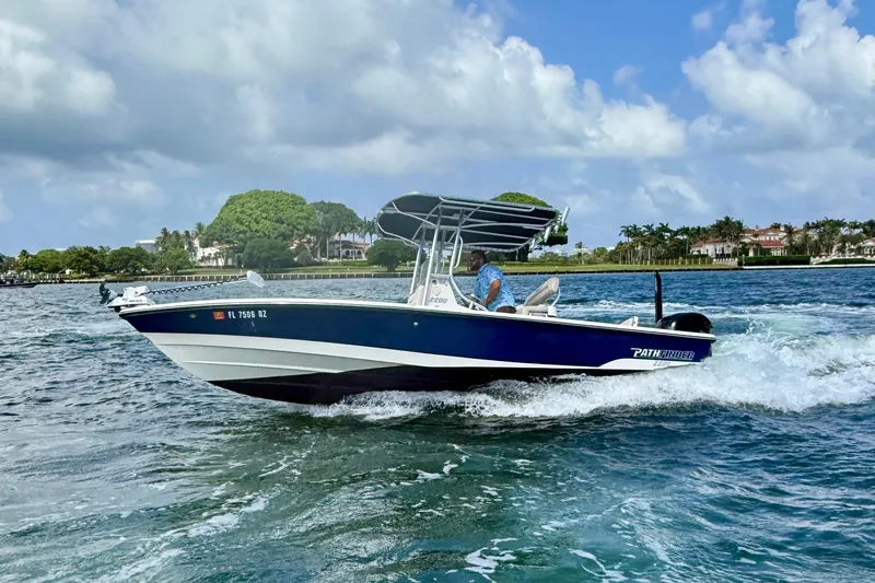 Slide: The Image of 2012 Pathfinder 2200 TRS boat cruising on a sunny day with scenic waterfront homes. - 3