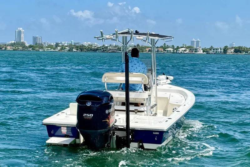 Slide: The Image of 2012 Pathfinder 2200 TRS boat cruising on blue water near city skyline. - 5