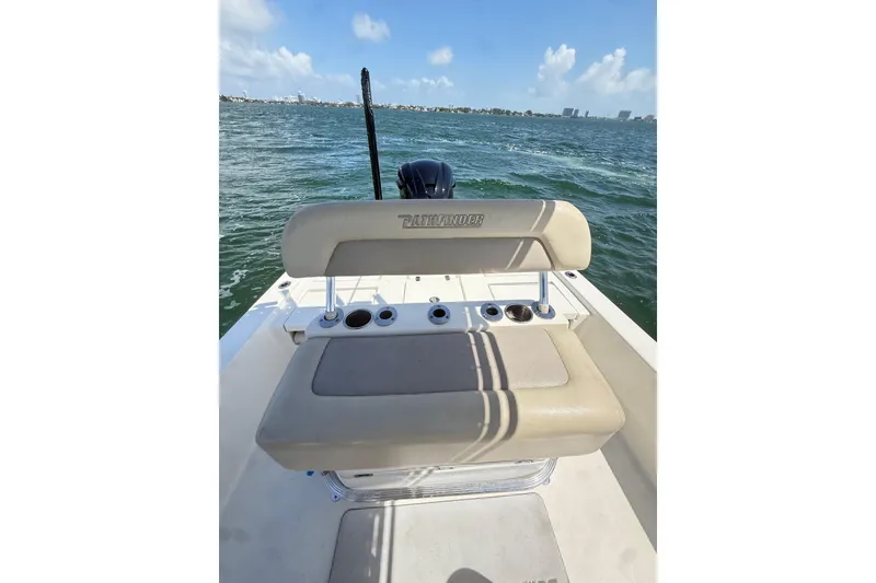 Slide: The Image of 2012 Pathfinder 2200 TRS boat on water, featuring beige seating and rod holders. - 6