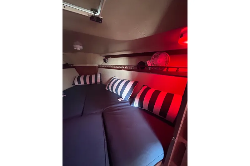 Slide: The Image of Cozy cabin interior of 1981 Catalina 30 sailboat with striped pillows and red lighting. - 11