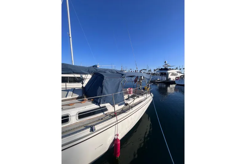 Slide: The Image of 1981 Catalina 30 sailboat docked in a marina under clear blue skies. - 2