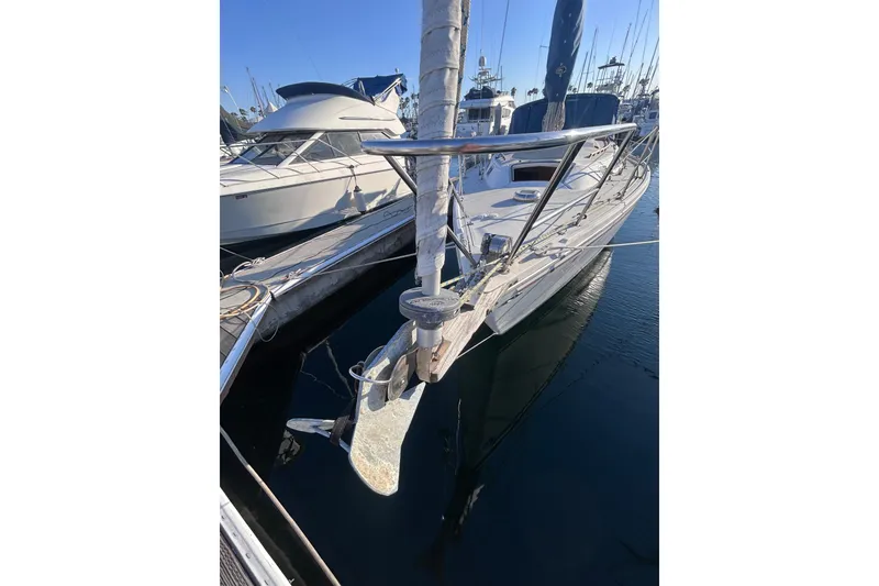 Slide: The Image of 1981 Catalina 30 sailboat docked in marina, front view with anchor visible. - 4