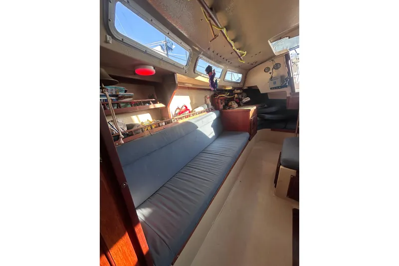 Slide: The Image of Interior of a 1981 Catalina 30 sailboat with blue seating and wooden accents. - 8