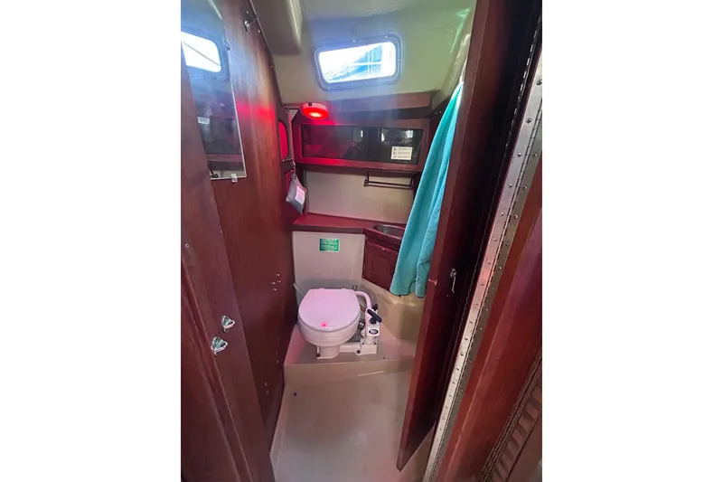 Slide: The Image of Interior of 1981 Catalina 30 sailboat bathroom with toilet and wooden cabinetry. - 9