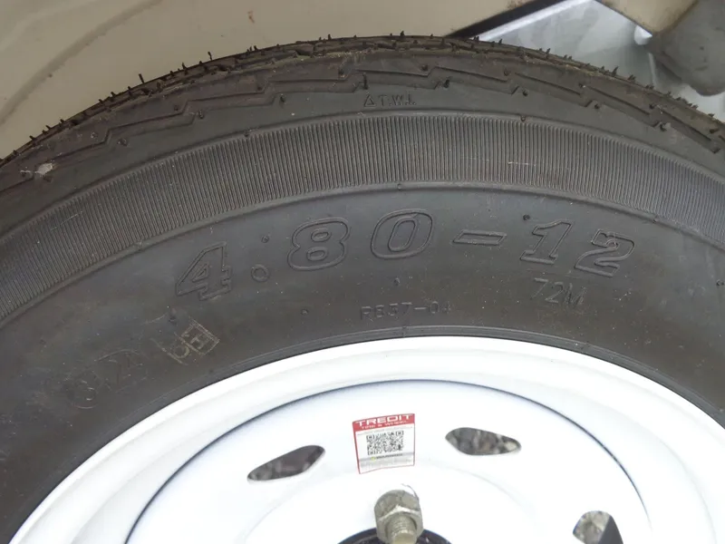 Slide: The Image of Close-up of a tire marked 4.80-12 on a white rim. - 34