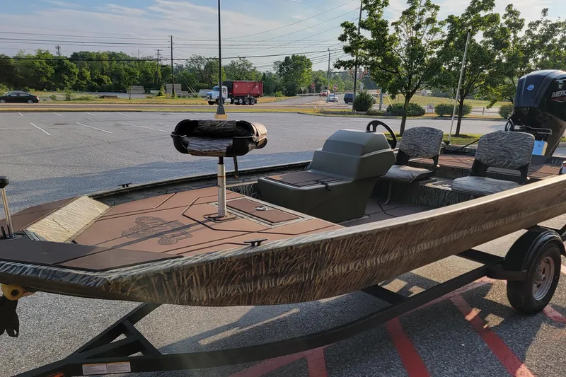 Slide: The Image of 2026 Tracker Grizzly 1754 SC boat in parking lot, featuring camo design and seating. - 4