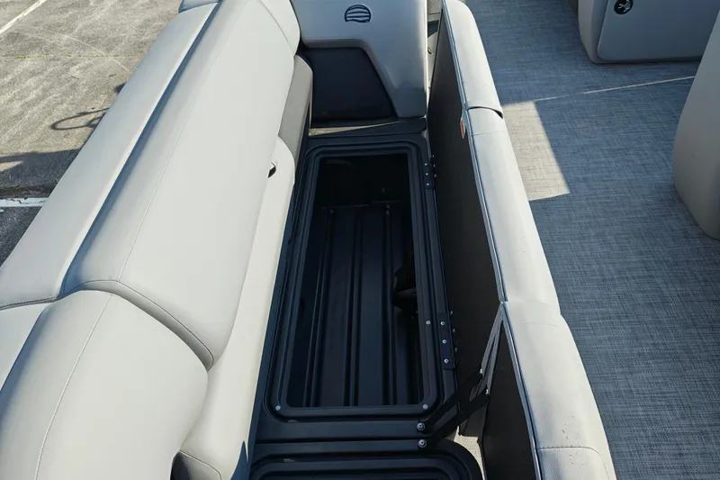 Slide: The Image of 2026 Sun Tracker Party Barge 20 DLX interior storage compartment with gray seating. - 18