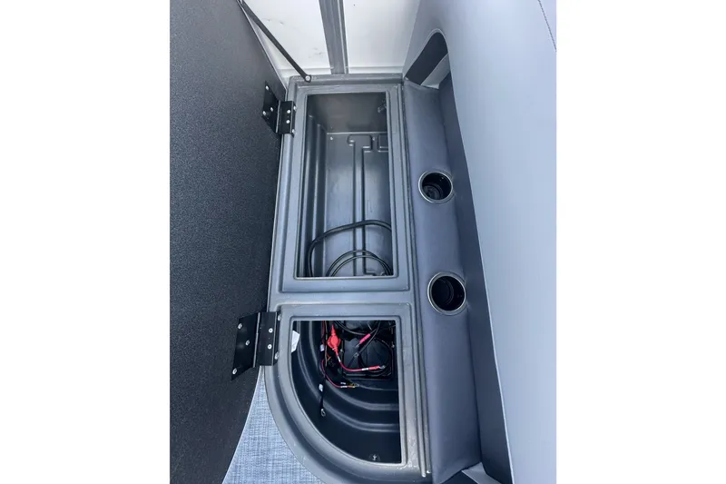 Slide: The Image of Storage compartment of 2026 Sun Tracker Party Barge 16 DLX with wiring and cup holders. - 16