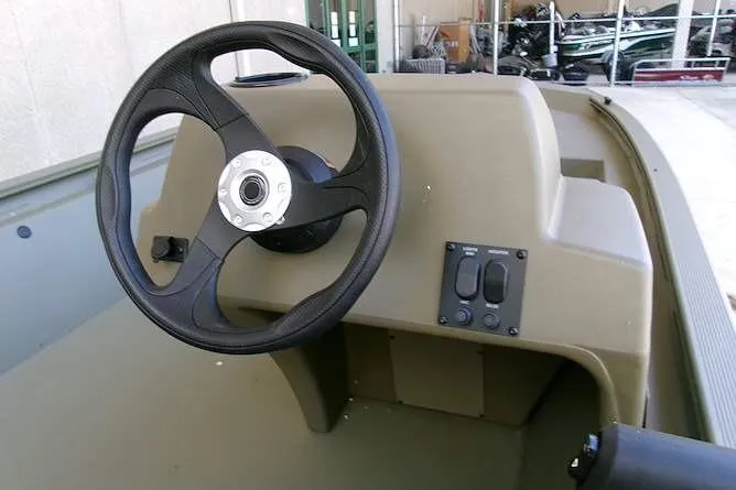 Slide: The Image of Steering console of 2026 Tracker Grizzly 1648 SC boat, featuring a sleek black wheel. - 5