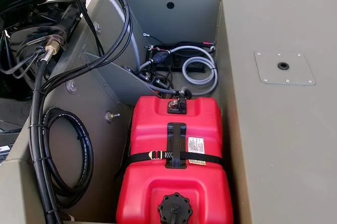 Slide: The Image of 2026 Tracker Grizzly 1648 SC boat compartment with red fuel tank and wiring. - 6