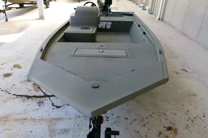 Slide: The Image of 2026 Tracker Grizzly 1648 SC boat, gray exterior, parked indoors on concrete floor. - 3