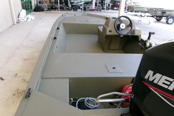 Slide: The Image of 2026 Tracker Grizzly 1648 SC boat with steering console and Mercury engine in a showroom. - 4