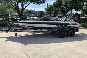 Slide: The Image of 2026 Ranger Z519R boat on trailer, parked outdoors under trees. - 5