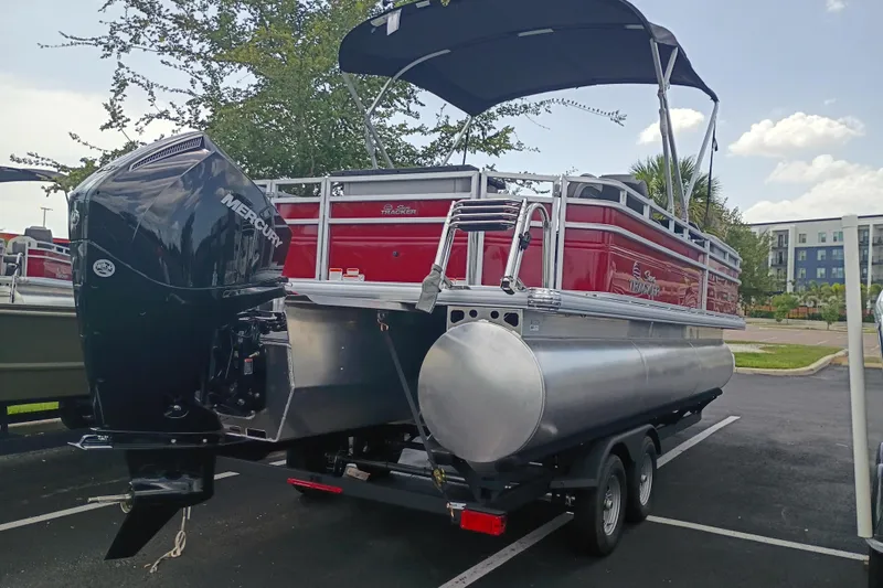 Slide: The Image of 2026 Sun Tracker SportFish 22 XP3 pontoon boat with Mercury engine in parking lot. - 1