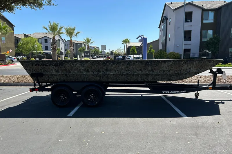 The Image of 2026 Tracker Grizzly 2072 Utility boat on trailer in urban parking lot. - 0