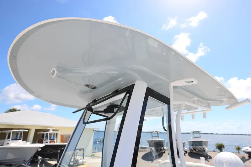 Slide: The Image of 2026 Sea Hunt Ultra 239 SE boat with sleek T-top design under clear blue sky. - 16