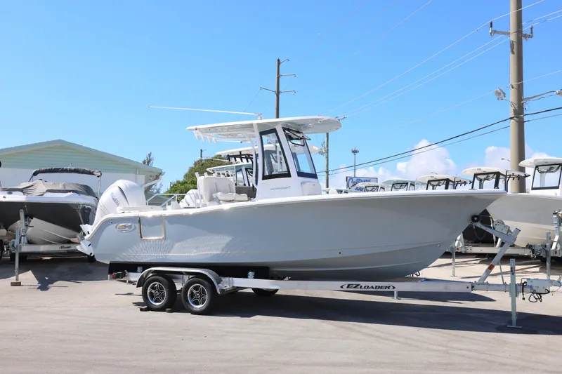 Slide: The Image of 2026 Sea Hunt Ultra 239 SE boat on trailer, displayed outdoors under clear sky. - 18