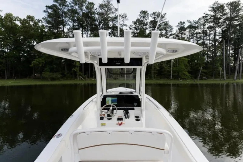 Slide: The Image of Manufacturer Provided Image: 2026 Sea Hunt Ultra 239 SE boat on calm water, surrounded by trees. - 25