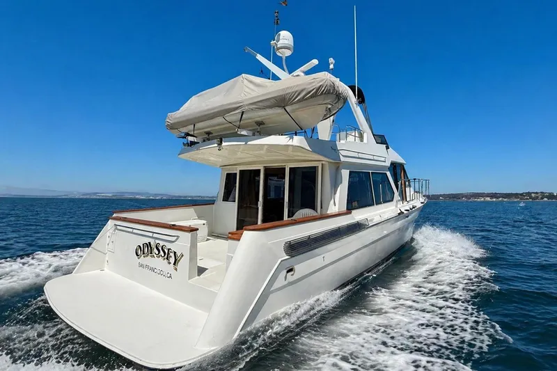 The Image of 1997 Navigator Pilothouse yacht "Odyssey" cruising on open water under clear blue skies. - 0