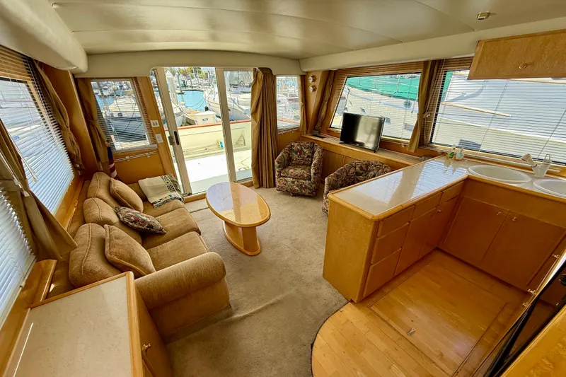 Slide: The Image of Luxurious 1997 Navigator Pilothouse yacht interior with cozy seating, kitchenette, and marina view. - 12