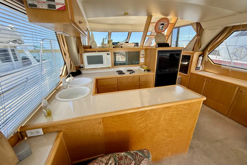 Slide: The Image of Interior of a 1997 Navigator Pilothouse yacht with kitchen and seating area. - 13