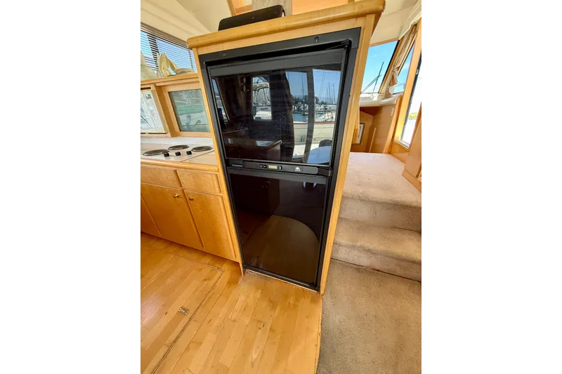 Slide: The Image of Interior of 1997 Navigator Pilothouse yacht with wooden cabinetry and carpeted steps. - 15