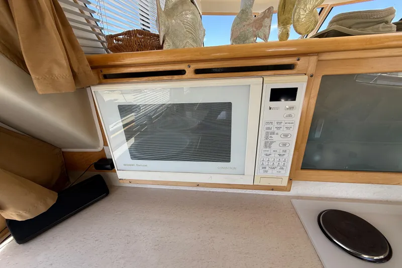 Slide: The Image of Built-in microwave in 1997 Navigator Pilothouse kitchen with wooden cabinetry and decor. - 16