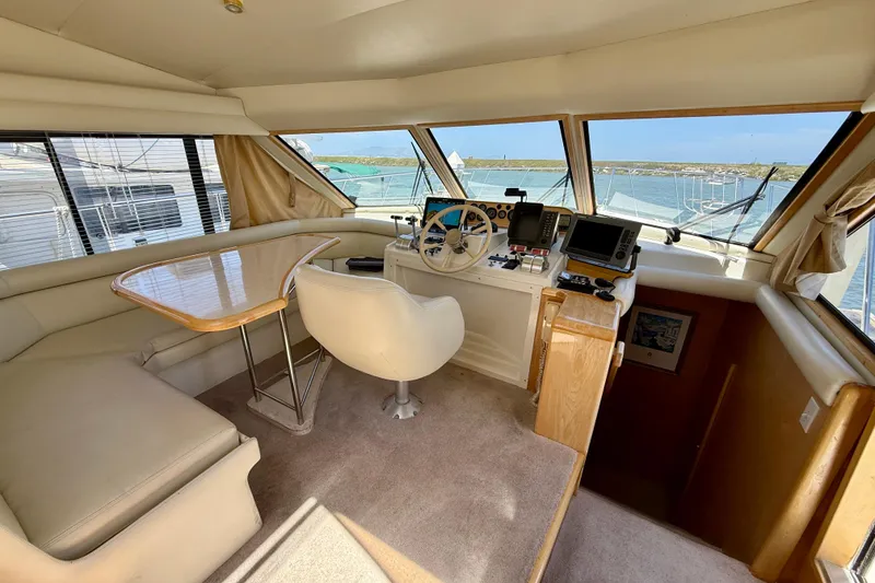 Slide: The Image of 1997 Navigator Pilothouse yacht interior with helm, seating, and navigation equipment. - 18
