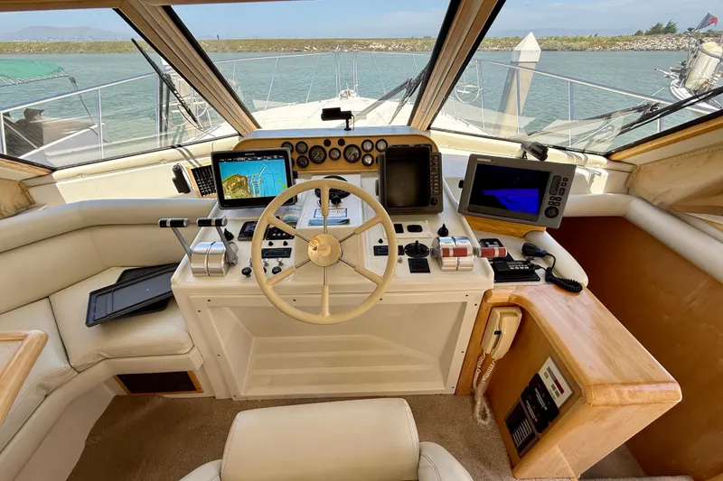 Slide: The Image of 1997 Navigator Pilothouse helm with steering wheel, navigation screens, and control panels. - 20