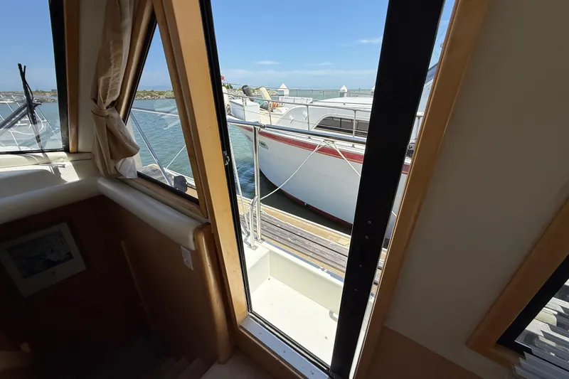 Slide: The Image of View from 1997 Navigator Pilothouse, showcasing marina and adjacent boat through cabin window. - 21
