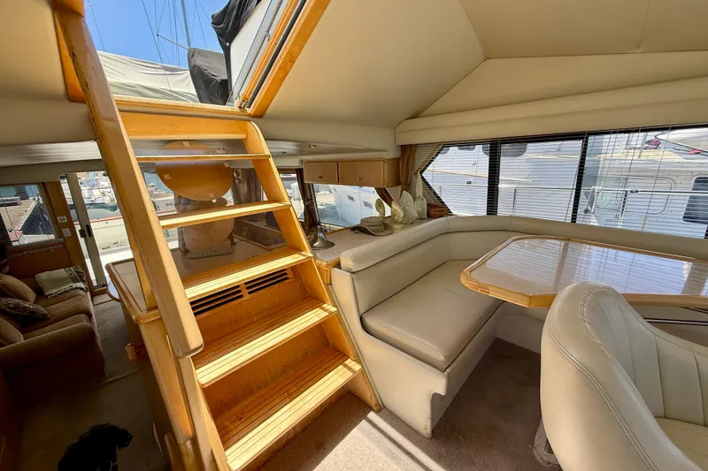 Slide: The Image of Interior of 1997 Navigator Pilothouse yacht with wooden stairs and cozy seating area. - 29