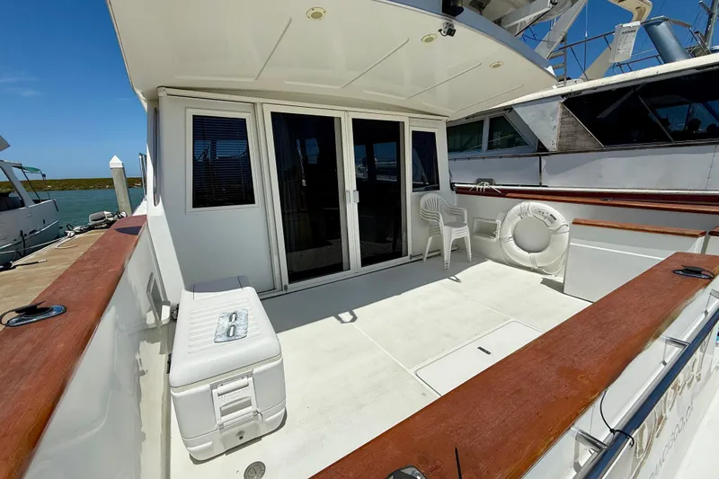 Slide: The Image of 1997 Navigator Pilothouse yacht deck with seating, life preserver, and ocean view. - 3