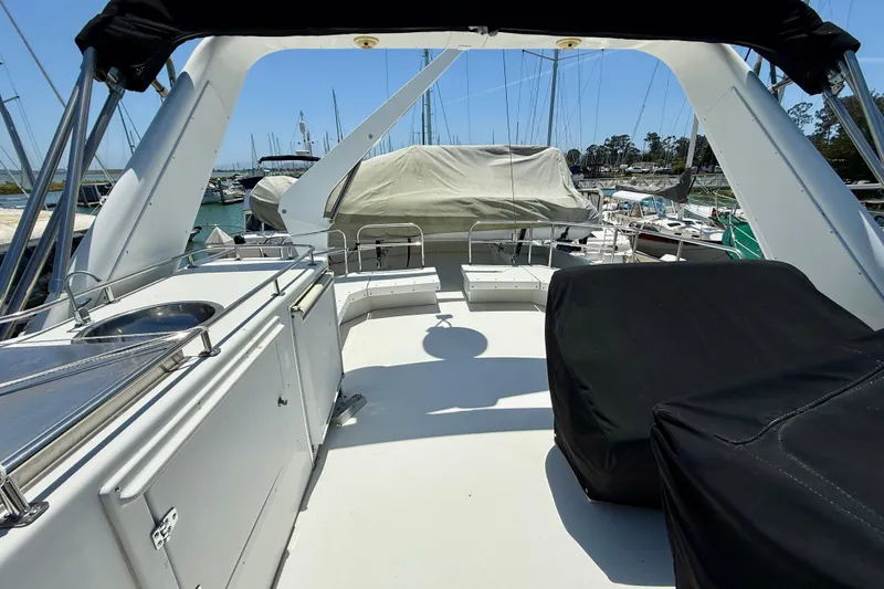 Slide: The Image of 1997 Navigator Pilothouse yacht deck with seating and covered equipment in a marina. - 30