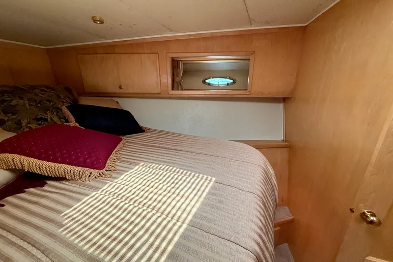 Slide: The Image of Cozy bedroom in 1997 Navigator Pilothouse yacht with wooden interior and decorative pillows. - 39