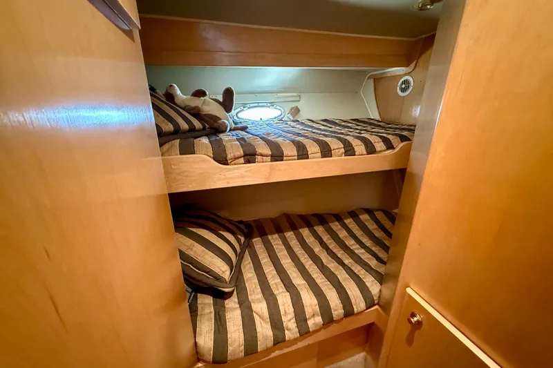 Slide: The Image of Bunk beds in 1997 Navigator Pilothouse yacht cabin with striped bedding and wooden interior. - 42