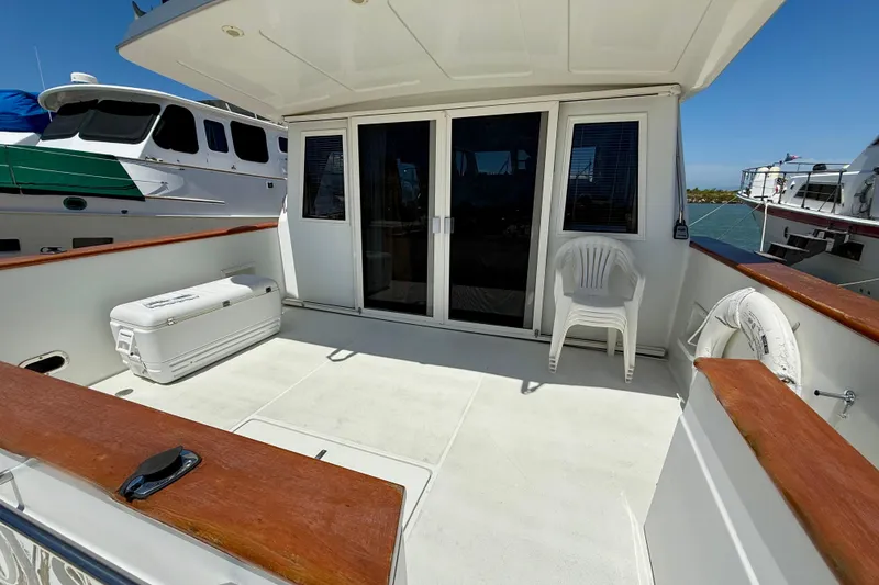 Slide: The Image of 1997 Navigator Pilothouse yacht deck with seating, cooler, and life preserver. - 6