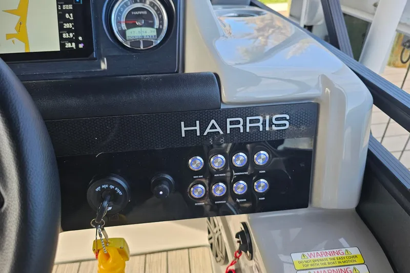 Slide: The Image of Control panel of a 2024 Harris boat with switches and key ignition. - 12
