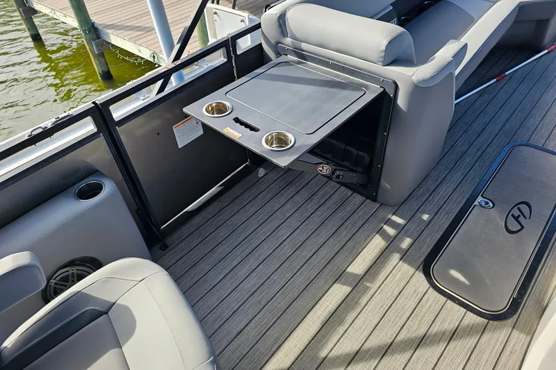 Slide: The Image of 2024 Harris boat interior with foldable table and cup holders on deck. - 13