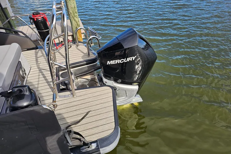 Slide: The Image of 2024 Harris boat with Mercury outboard motor on water, featuring sleek deck design. - 15